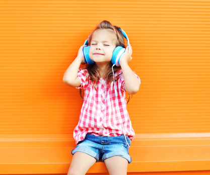 Little Girl Wearing Headphones While Listening to Music